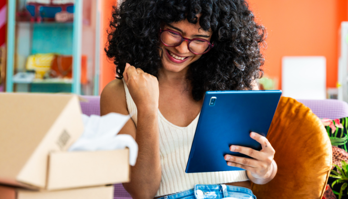 Happy reseller looking at a tablet, symbolizing the success and profits from following this strategy.